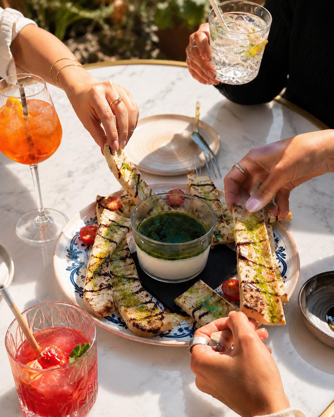 Moment convivial autour d'assiettes à partager et de cocktails en terrasse
